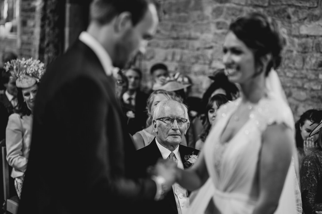 Dad watches his daughter exchange rings with her groom. 